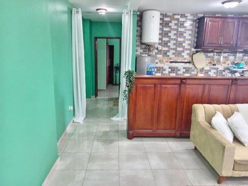 a living room with green walls and a couch at Matera YameHome in Yaoundé