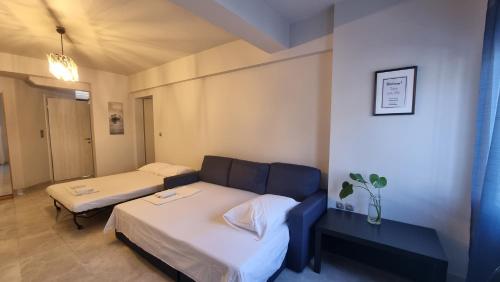 - une salle d'hôpital avec 2 lits et un canapé dans l'établissement Seaside Luxury Suites by Sarigianni, à Paralia Katerinis
