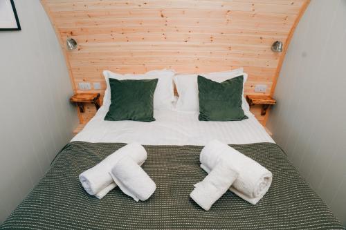 a bedroom with a large bed with a wooden headboard at Eastfield Glamping Farm in Spennithorne