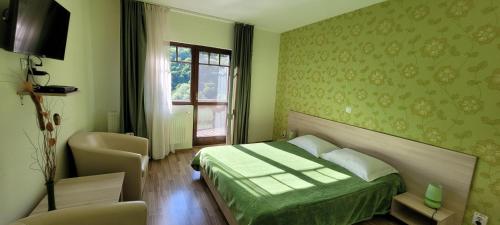 a green bedroom with a bed and a window at Complex Turistic Perla Trascaului in Rimetea