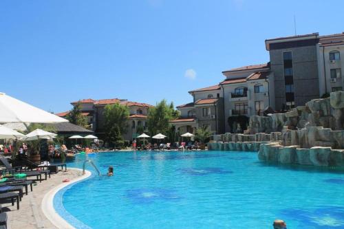 uma grande piscina com pessoas na água em Large studio apartment , 4* spa resort, The Vineyards. em Aheloy