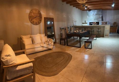 sala de estar con sofás, mesa y reloj en Huellas del Trapiche Apart in 