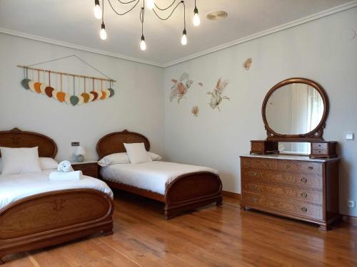 1 dormitorio con 2 camas, espejo y tocador en Casa Albaitar Jardin privado exclusivo clientes en Azcona