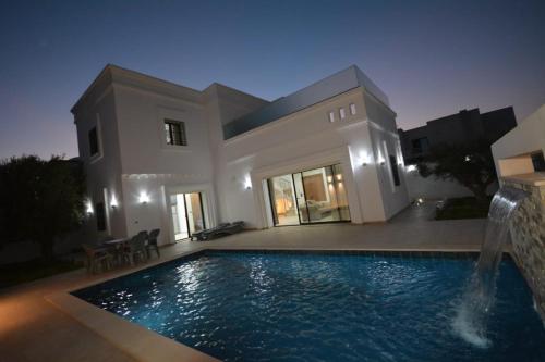 una casa con piscina frente a una casa en Diar Nader, en Midoun