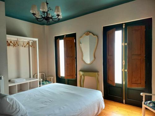 - une chambre avec un lit et un miroir mural dans l'établissement Apartamento Ábside de San Juan III, à Estella