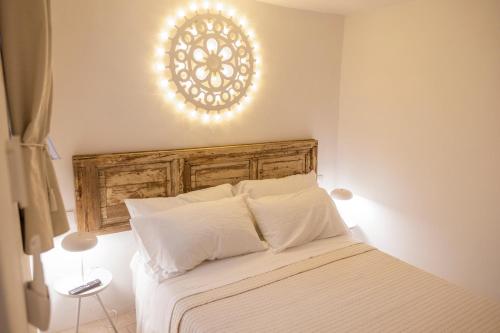 a bedroom with a white bed with a wooden headboard at Rosa Trulli suite in Alberobello