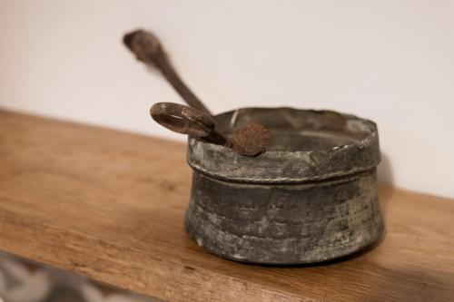 a metal container with a spoon on a wooden table at Rosa Trulli suite in Alberobello