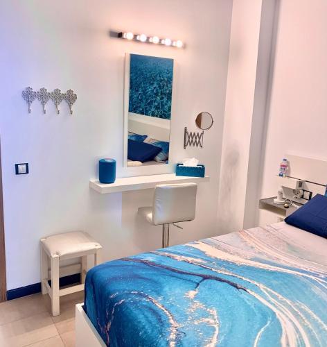 a bedroom with a bed and a mirror and a chair at Calypso in Cotillo