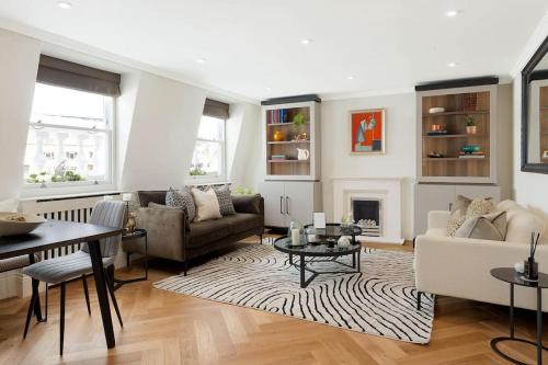 a living room with a couch and a table at South Kensington Luxury Apartment Balcony, Museums & Heathrow 30min in London
