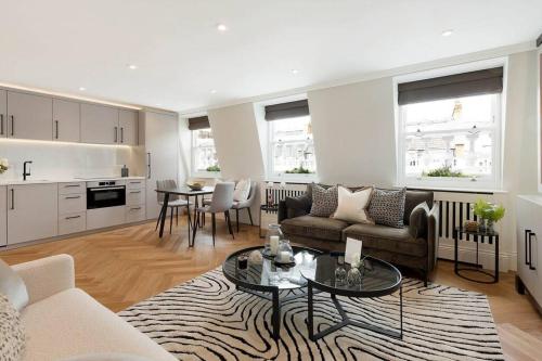 a living room with a couch and a table at South Kensington Luxury Apartment Balcony, Museums & Heathrow 30min in London