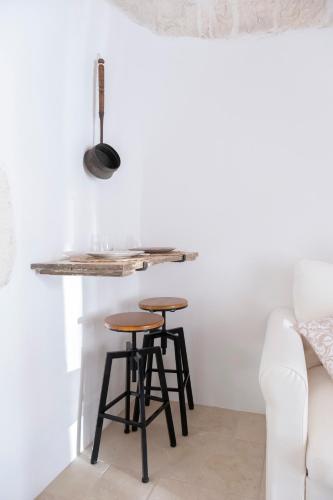 a kitchen with two bar stools and a counter at Rosa Trulli suite in Alberobello