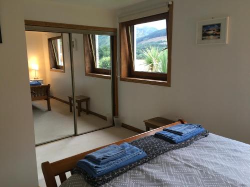 1 dormitorio con 1 cama con 2 toallas azules en Heron’s View, en Arrochar