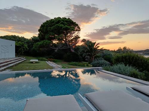 una piscina con puesta de sol en el fondo en Summer Villa in Porto Rafti, en Porto Rafti