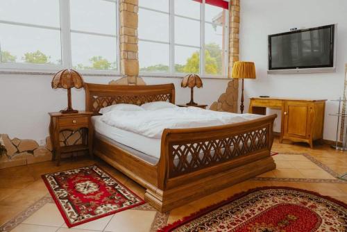 Murów的住宿－Da Enzo，一间卧室配有一张大型木床和一台平面电视。