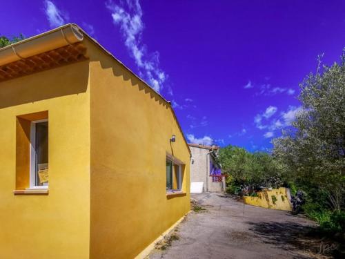a yellow building with a blue sky in the background at Grand Studio provençal, piscine vue magnifique in Carnoules