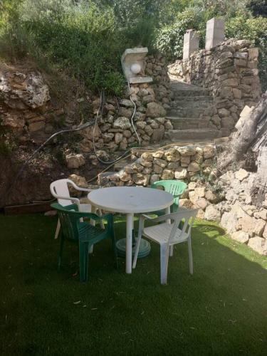 a white table and chairs in the grass at Grand Studio provençal, piscine vue magnifique in Carnoules