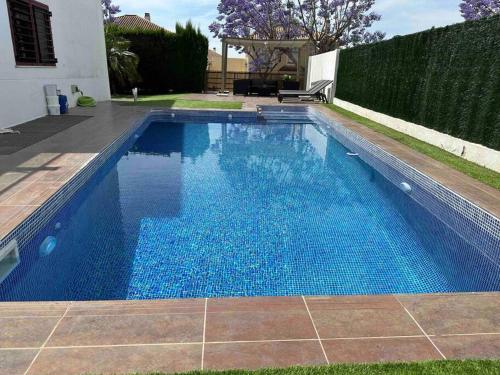 uma piscina com água azul num quintal em Modern 5-bedroom villa with pool em Montequinto