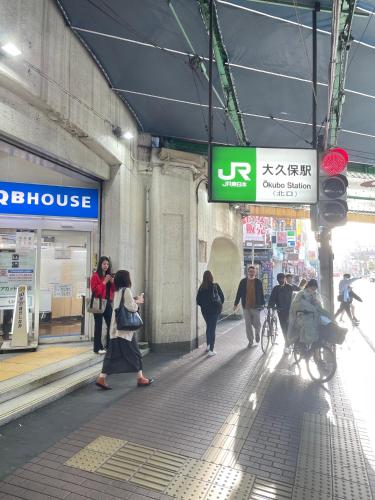 a group of people walking on a street in a building at 新宿の家-畳み3部屋 Maison à Shinjuku - pedalmi chambre 3 personnes 106 in Tokyo