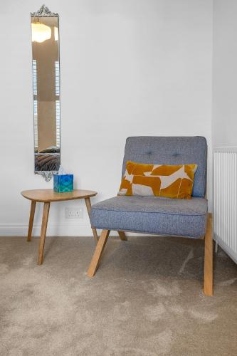 a blue chair and a table in a room at Beeswing, a Victorian Gem in Biggar in Biggar
