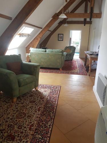sala de estar con 2 sillas y sofá en gite de la brasserie, en Saulgé