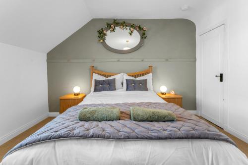 a bedroom with a large bed with two pillows at Beeswing, a Victorian Gem in Biggar in Biggar