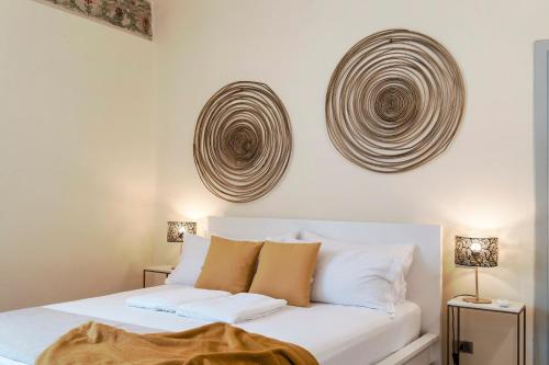 a bedroom with a white bed with white pillows at Iseo Portelle Holiday da Barbara - private parking & bike storage in Iseo