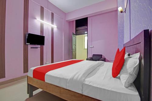 a bedroom with a large bed with red and white pillows at Super OYO Flagship Hotel Glorious Stayz in Noida