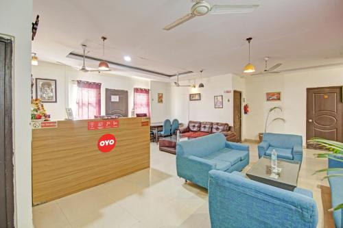 a lobby with blue chairs and a reception desk at Super OYO Flagship Hotel Glorious Stayz in Noida