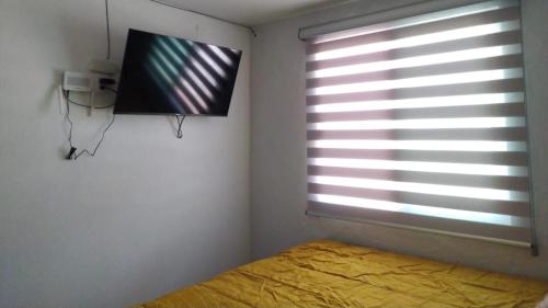 a bedroom with a bed and a window with blinds at HABITACION COMODA in Guadalajara