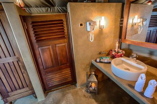 a bathroom with a sink and a mirror at Madulkelle Tea and Eco Lodge in Kandy