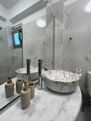 a marble bathroom with two sinks and a mirror at Nicolas Luxury Suites in Kourouta