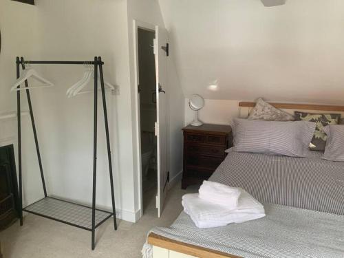 a bedroom with two beds and a mirror at Cosy Cottage in Sawbridgeworth