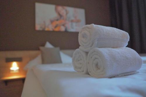 a pile of towels sitting on top of a bed at Hotel Frohnhauser Hof in Essen