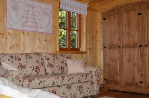 ein Wohnzimmer mit einem Sofa und einem Fenster in der Unterkunft Wohnen am See Villa Schrötter direkt am Traunsee in Rindbach