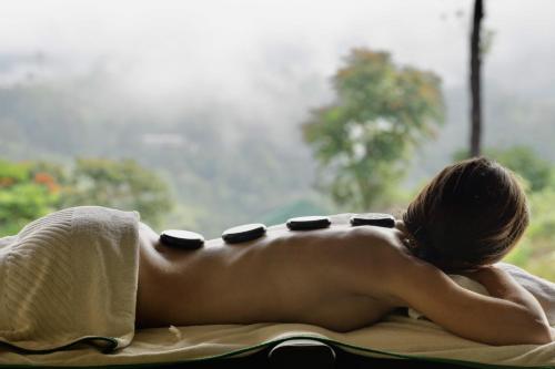 a woman laying on a towel in a window at Madulkelle Tea and Eco Lodge in Kandy