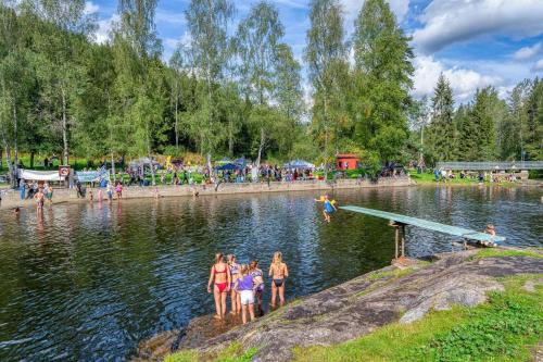 a group of people standing in the water at a park at Hanaborg apartment in Lorenskog