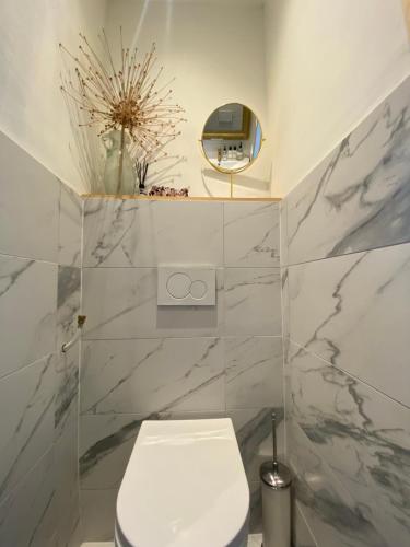 ein weißes Bad mit einem WC und einem Spiegel in der Unterkunft Vondelpark Suite in Amsterdam
