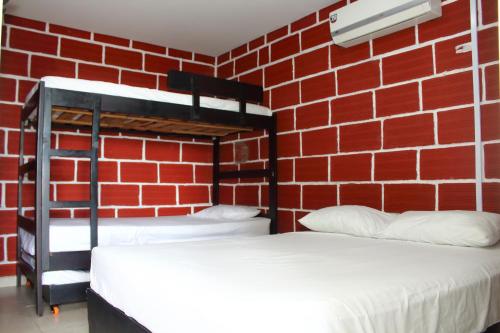 two bunk beds in a room with a brick wall at Hostal La Guaca in Cartagena de Indias