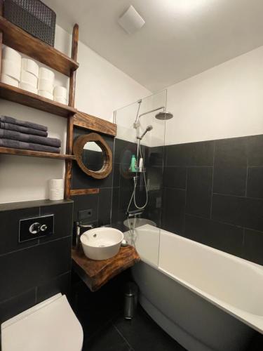 a bathroom with a sink and a tub and a toilet at Bougie Boutique Agenskalns in Rīga