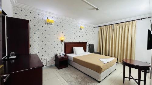 Habitación de hotel con cama y escritorio en Royal Prince Hotel, en Dubái