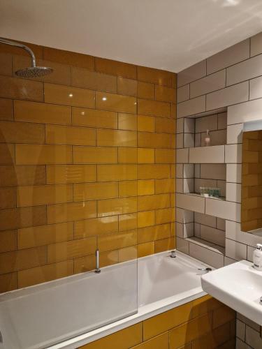 a bathroom with a tub and a sink at Modern two bedroom house in Ormiston