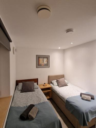a bedroom with two beds and a table at Modern two bedroom house in Ormiston
