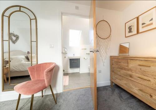 um quarto com um espelho, uma cadeira e uma cómoda em Huckleberry - Premium, Hot Tub, x2 Parking, Farm Shop Next door, Private Cornish Lane em Newquay