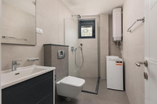 a bathroom with a shower and a toilet and a sink at Berge Apartments in Kotor
