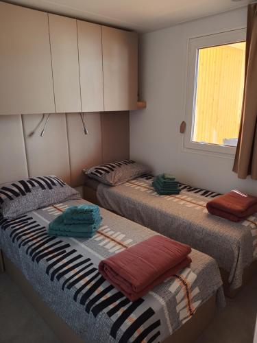 three beds sitting in a room with a window at Mobile Home Drage in Drage