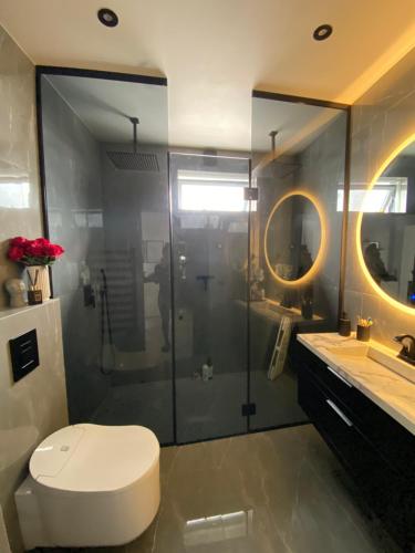 a bathroom with a toilet and a glass shower at Luxury villa with gym and sauna in Reykjavík