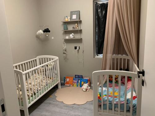 a baby room with two cribs and a window at Luxury villa with gym and sauna in Reykjavík