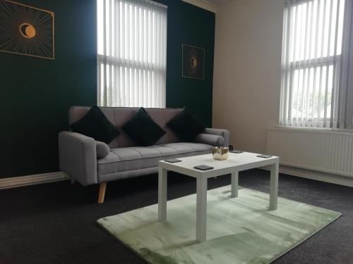 a living room with a couch and a table at Stylish City Central Outskirts Sleeps 8 in Leeds
