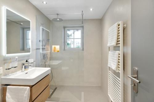 a white bathroom with a sink and a shower at Casa Tschuetta, Cadruvi 4, 7159 Andiast in Andest