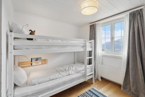 a white bunk bed in a white room with a window at Casa Tschuetta, Cadruvi 4, 7159 Andiast in Andest